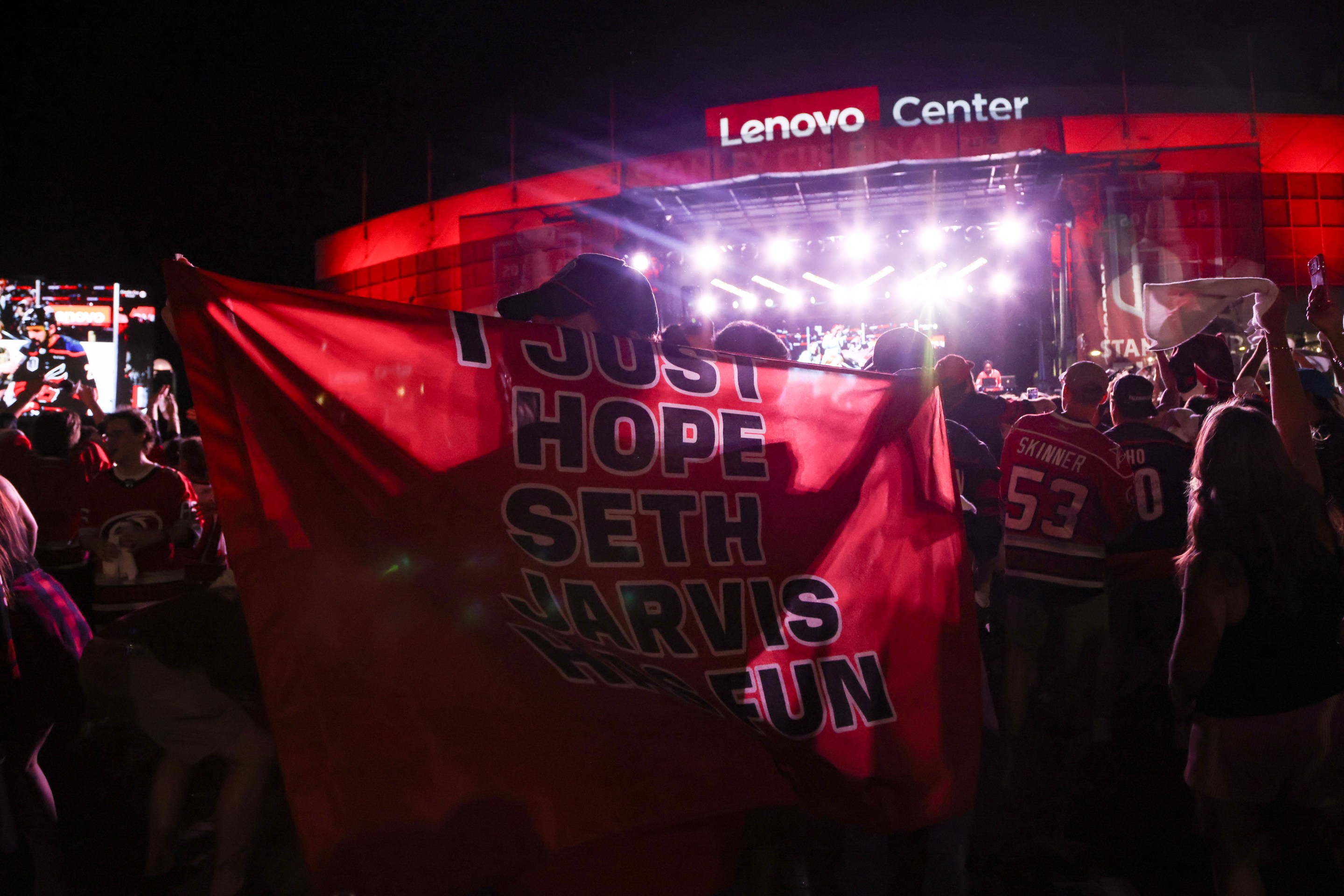 fan holds a cape reading "I just hope Seth Jarvis has fun" after game two of the Stanley Cup Finals on June 4, 2026 at Lenovo Arena