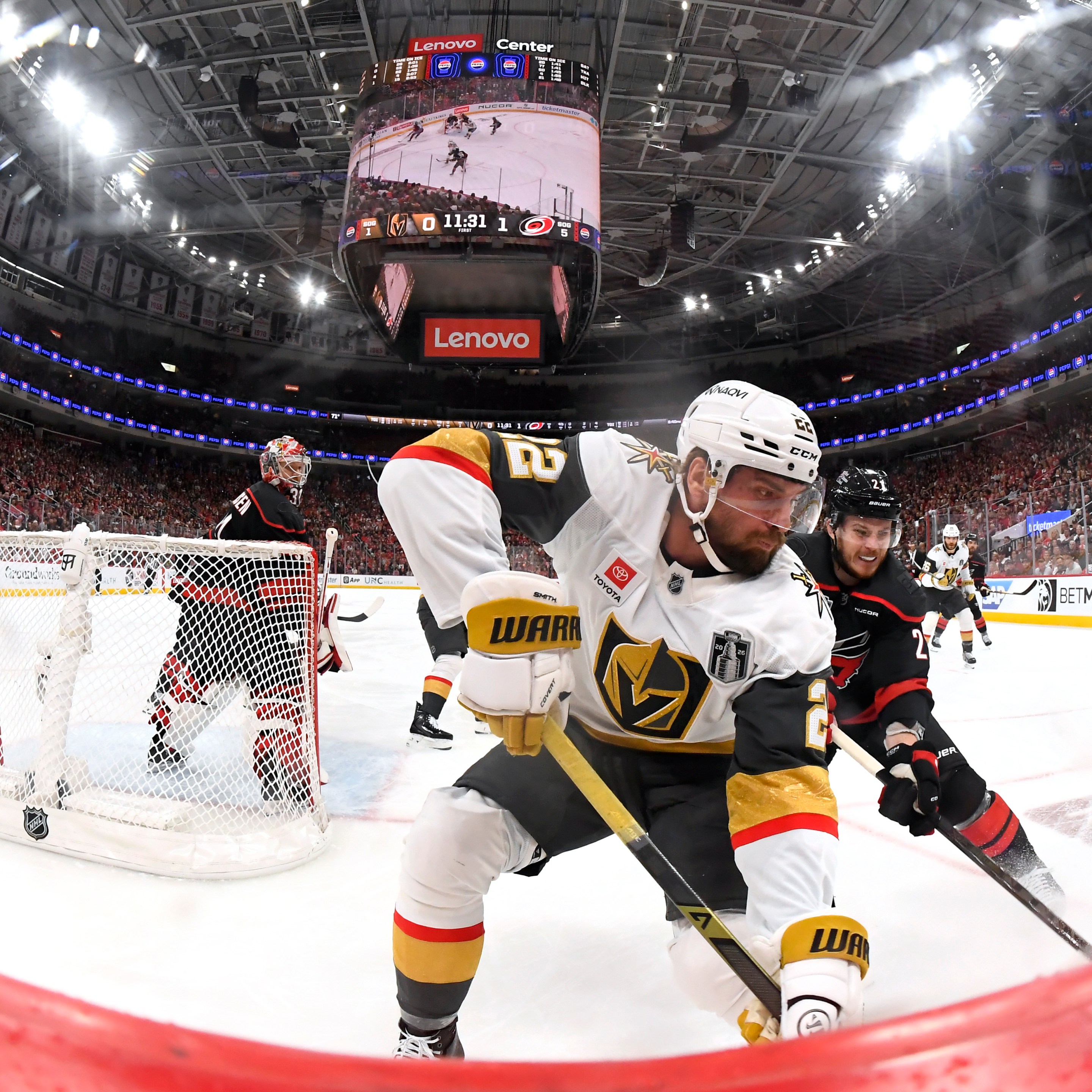 RALEIGH, NORTH CAROLINA - JUNE 02: Alexander Nikishin #21 of the Carolina Hurricanes pressures Cole Smith #22 of the Vegas Golden Knights at the boards during the third period of Game One of the Stanley Cup Final between the Vegas Golden Knights and the Carolina Hurricanes at Lenovo Center on June 02, 2026 in Raleigh, North Carolina. (Photo by Brian Babineau/NHLI via Getty Images)
