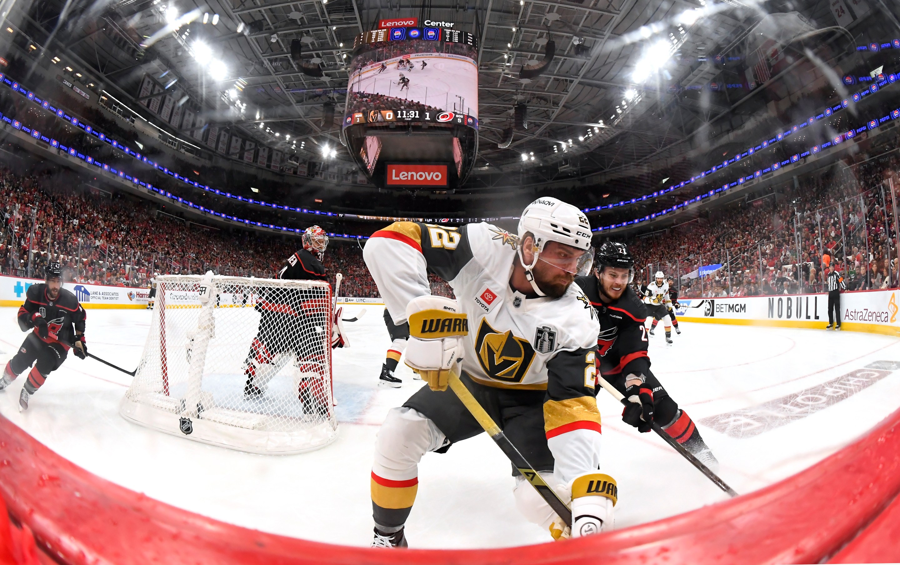 RALEIGH, NORTH CAROLINA - JUNE 02: Alexander Nikishin #21 of the Carolina Hurricanes pressures Cole Smith #22 of the Vegas Golden Knights at the boards during the third period of Game One of the Stanley Cup Final between the Vegas Golden Knights and the Carolina Hurricanes at Lenovo Center on June 02, 2026 in Raleigh, North Carolina. (Photo by Brian Babineau/NHLI via Getty Images)