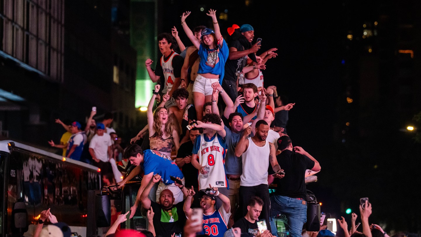 NEW YORK, NEW YORK - JUNE 14: New York Knicks fans climb on buses as they celebrate after they win the NBA Finals in Times Square on June 14, 2026 in New York City. The New York Knicks lead the San Antonio Spurs 3-1 and could win the franchise's first NBA championship since 1973 if they win tonight.(Photo by Adam Gray/Getty Images)