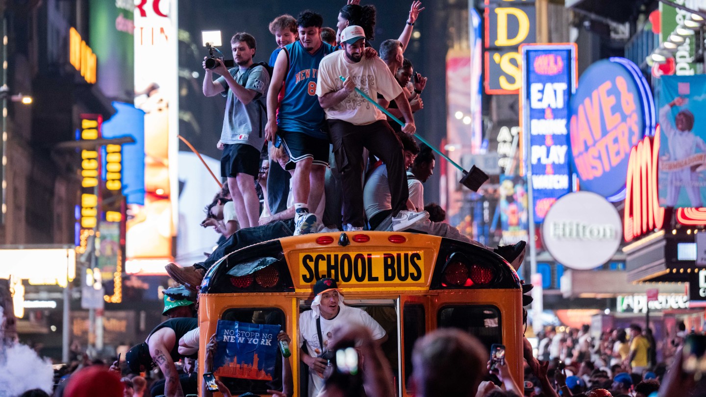 NEW YORK, NEW YORK - JUNE 14: New York Knicks fans climb on buses as they celebrate after they win the NBA Finals in Times Square on June 14, 2026 in New York City. The New York Knicks lead the San Antonio Spurs 3-1 and could win the franchise's first NBA championship since 1973 if they win tonight.(Photo by Adam Gray/Getty Images)