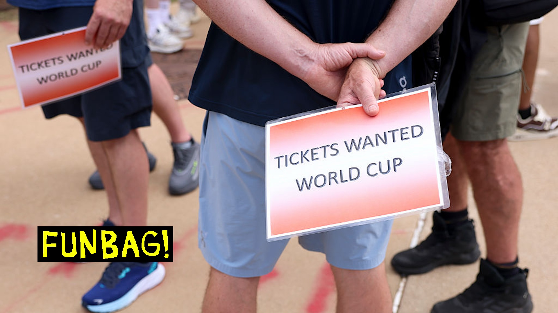 A world cup fan holds a sign soliciting tickets