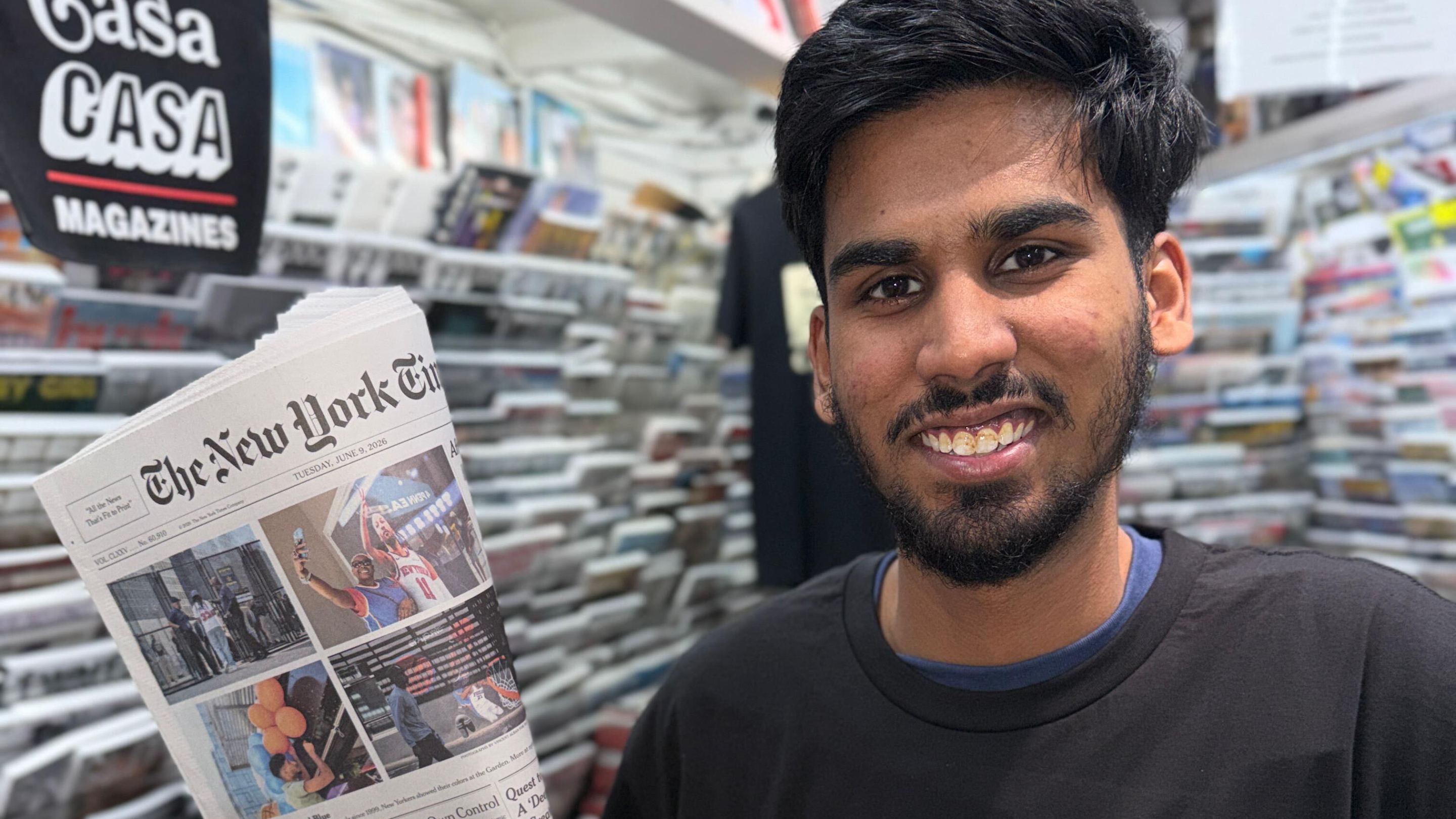 Casa Magazines staffer Mirza Ayan Baig holds up a recent Knicks front page.