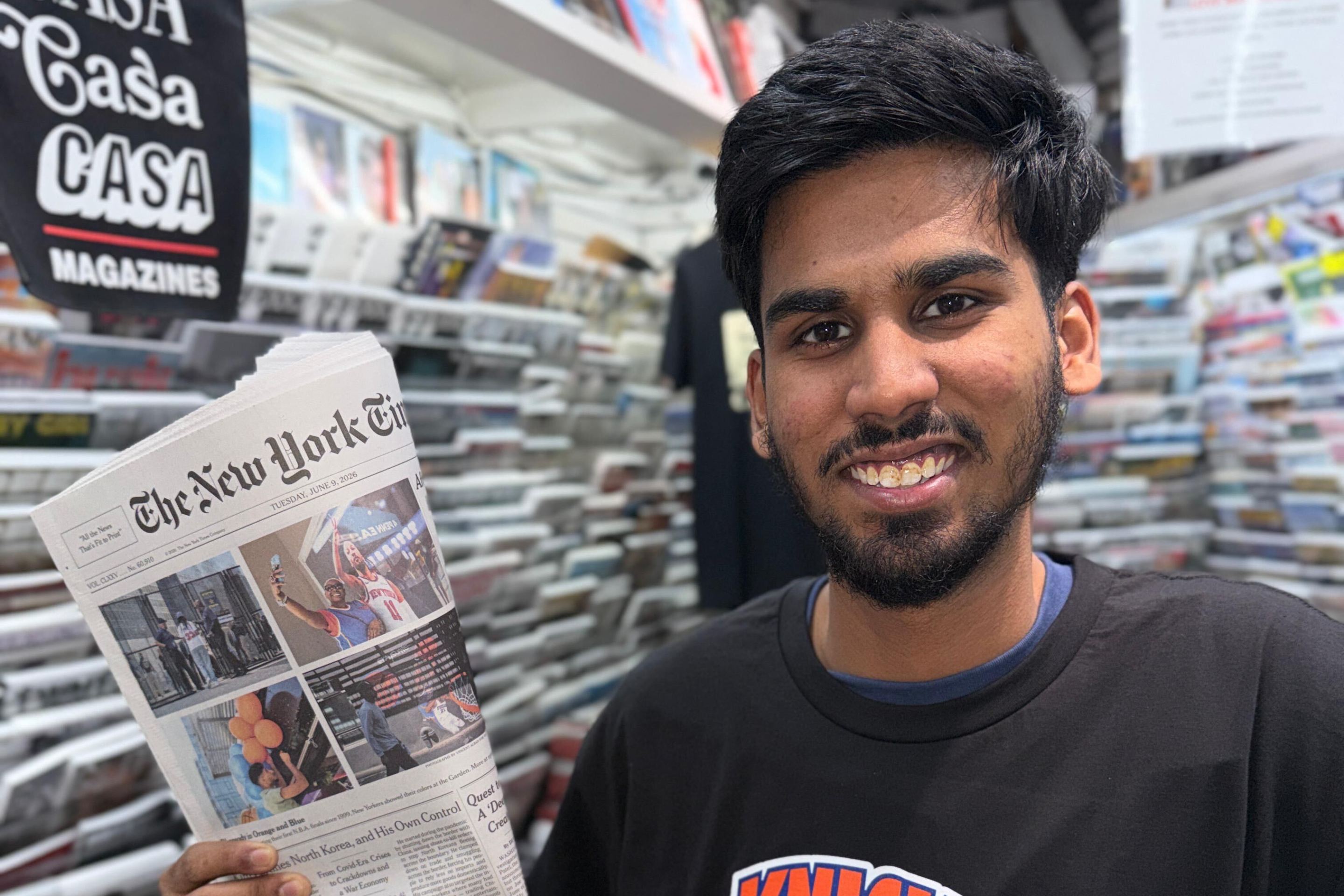Casa Magazines staffer Mirza Ayan Baig holds up a recent Knicks front page.