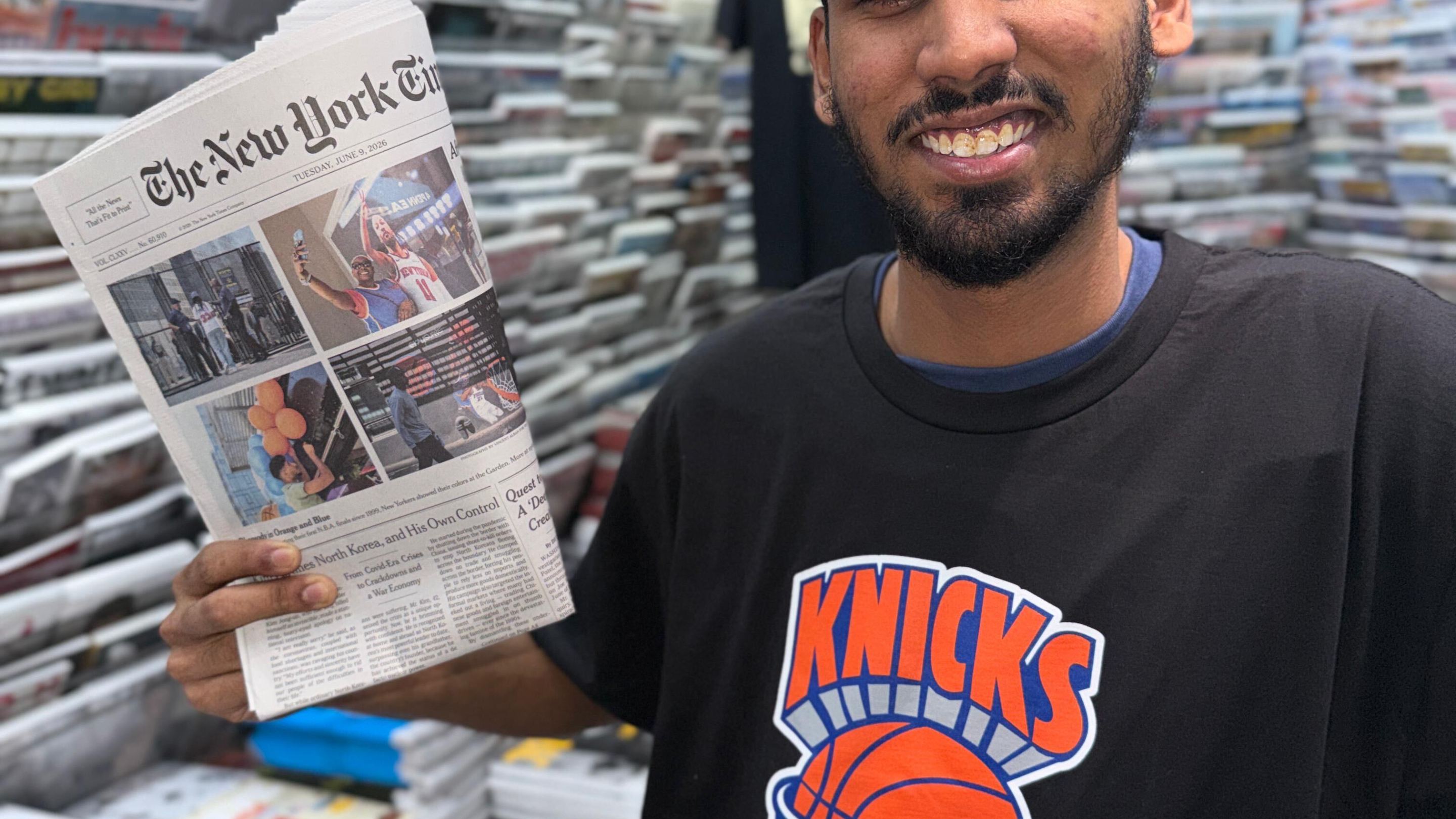 Casa Magazines staffer Mirza Ayan Baig holds up a recent Knicks front page.