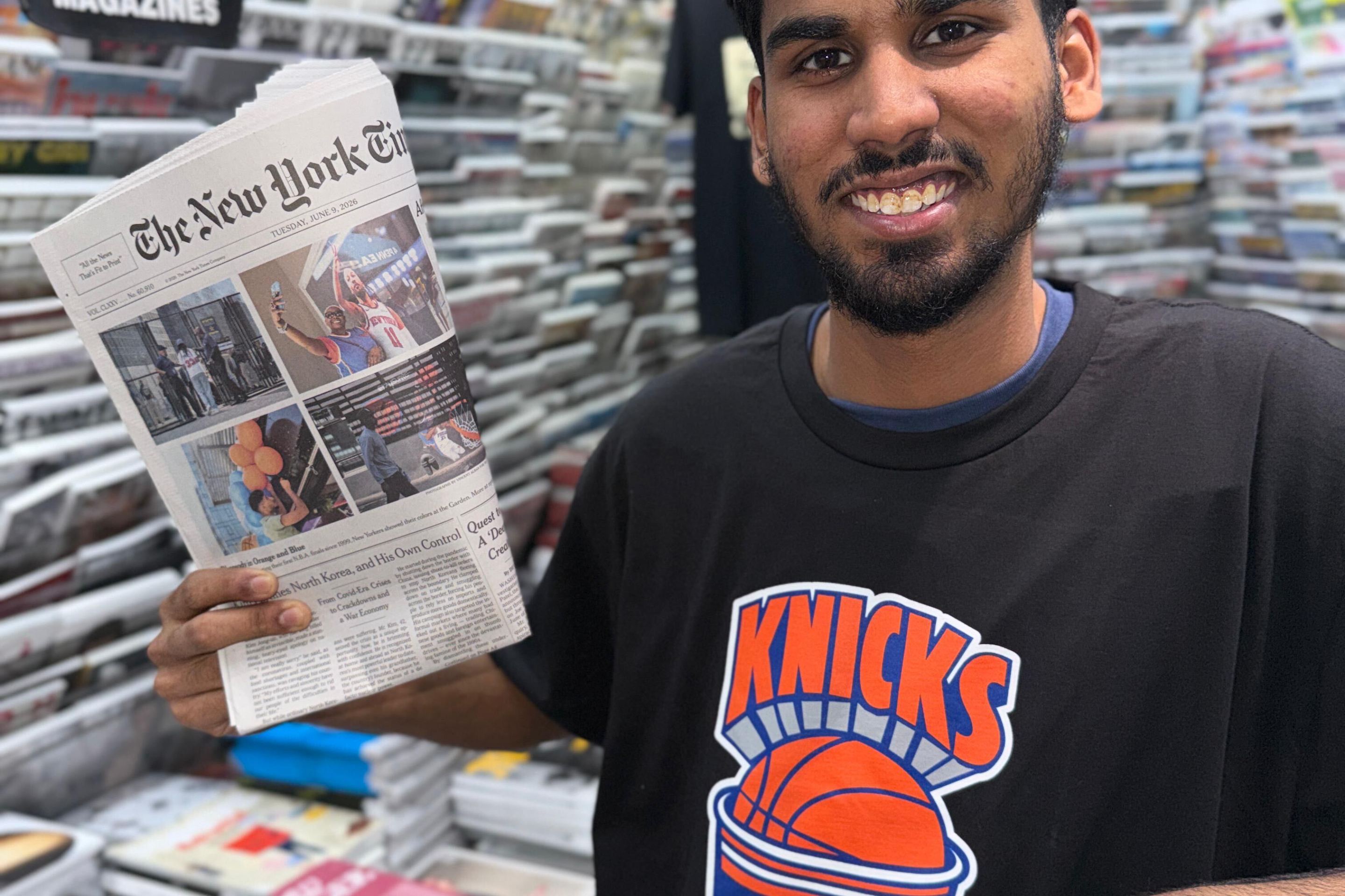 Casa Magazines staffer Mirza Ayan Baig holds up a recent Knicks front page.