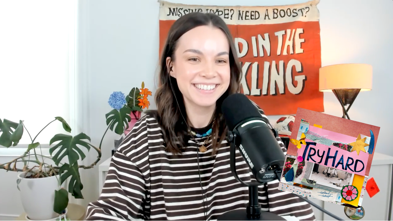 ingrid nilsen sits behind a mic in a brown and white striped shirt. there is a flag and a plant behind her .