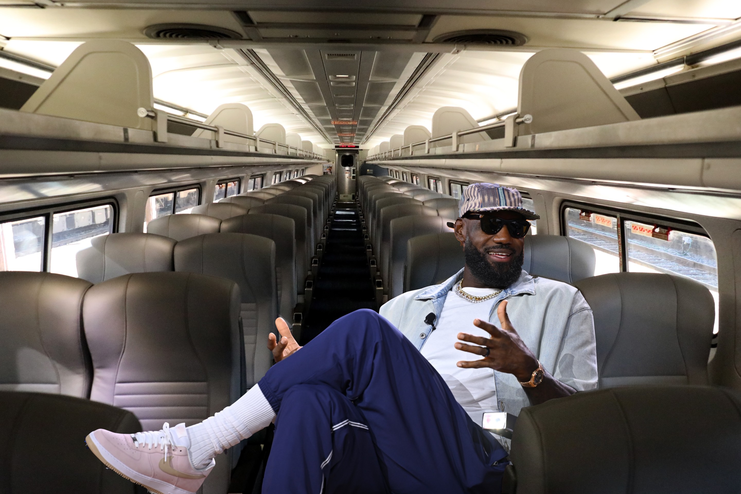 Theoretical visualization of LeBron James sitting on a standard Amtrak car.