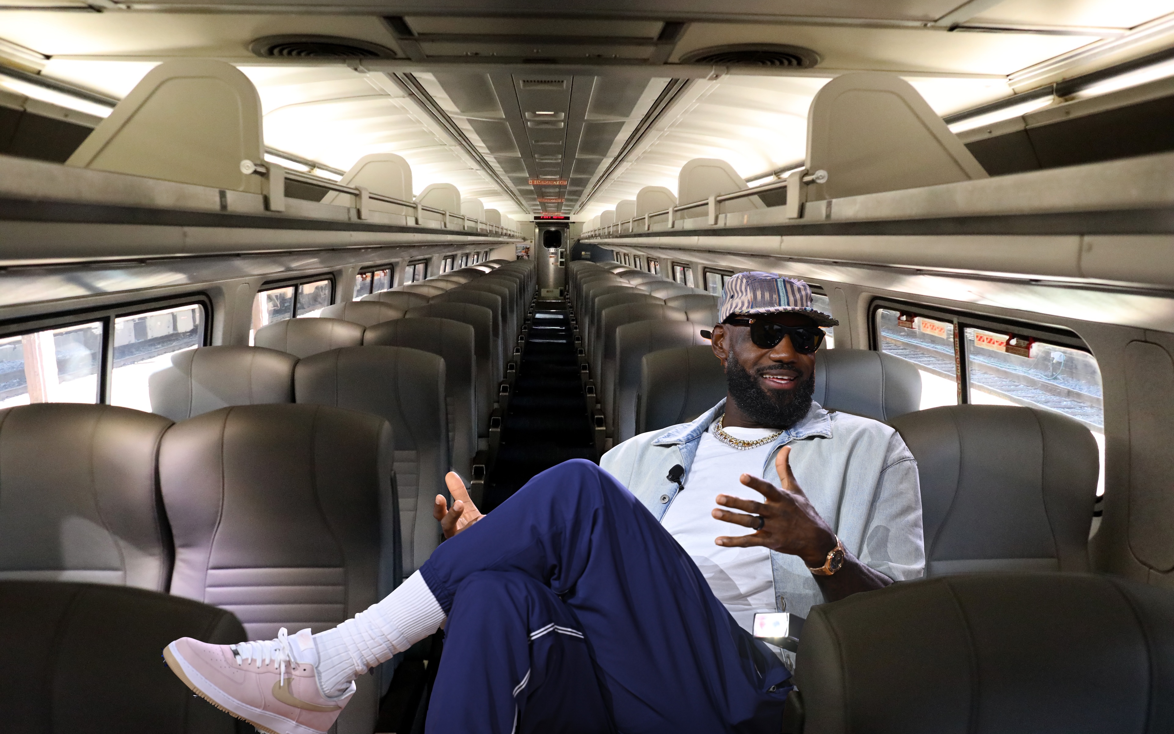 Theoretical visualization of LeBron James sitting on a standard Amtrak car.