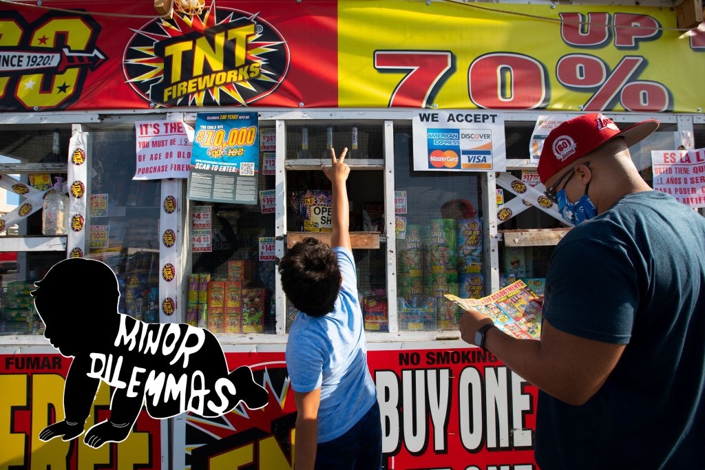 A father and son buy fireworks at a stand