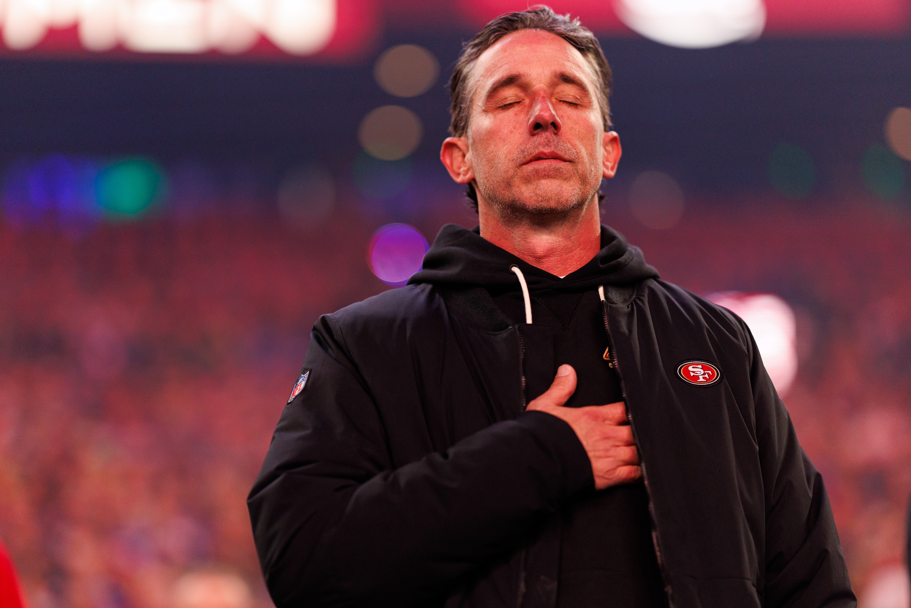 Head coach Kyle Shanahan of the San Francisco 49ers stands on the sidelines during the national anthem prior to an NFL divisional playoff football game against the Seattle Seahawks at Lumen Field on January 17, 2026 in Seattle, Washington.