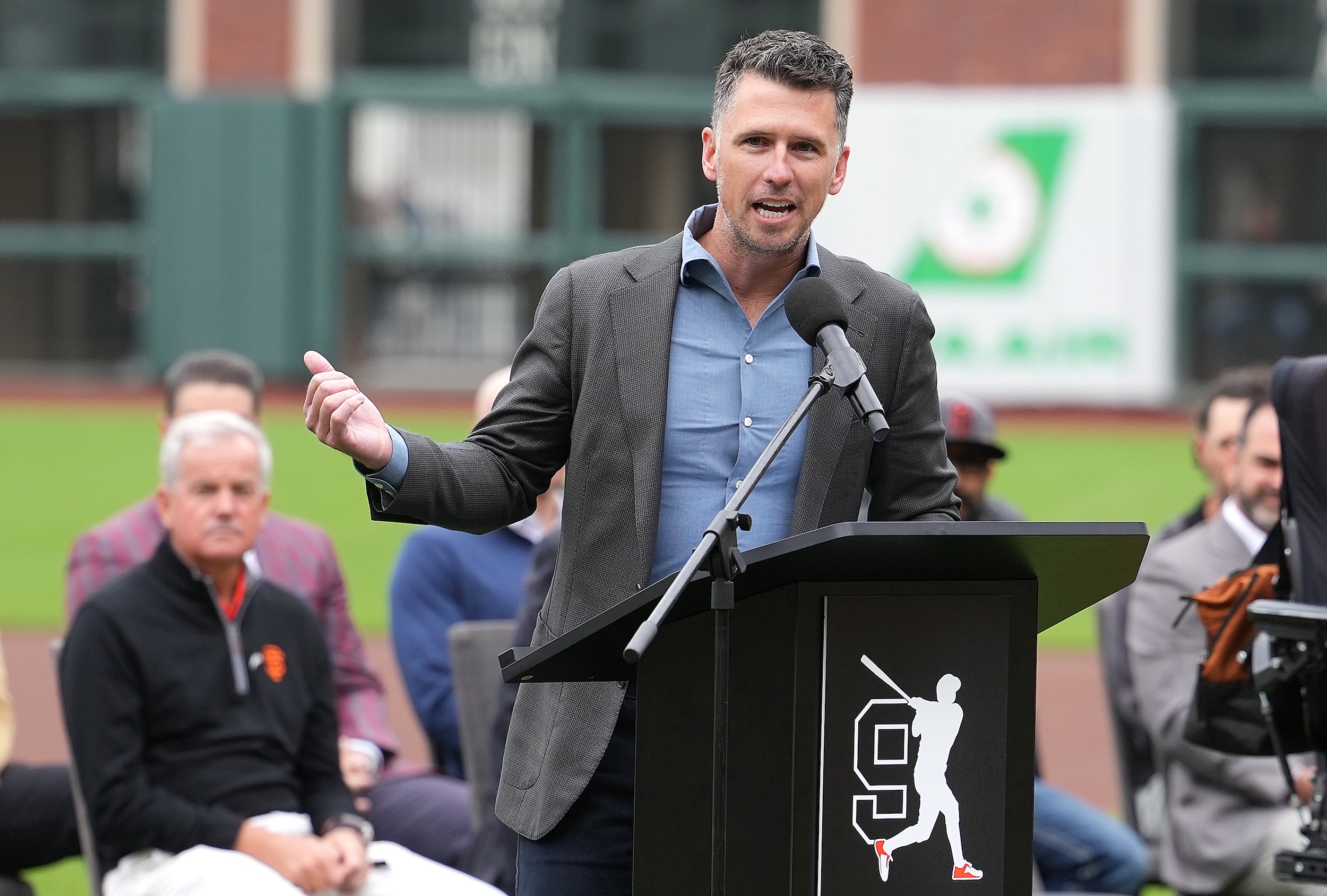 Buster Posey talks at a microphone.