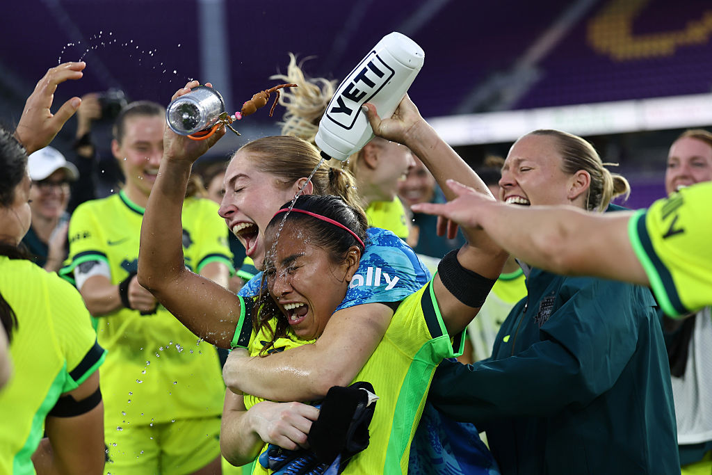 Leicy Santos's teammates dowse her in water while celebrating