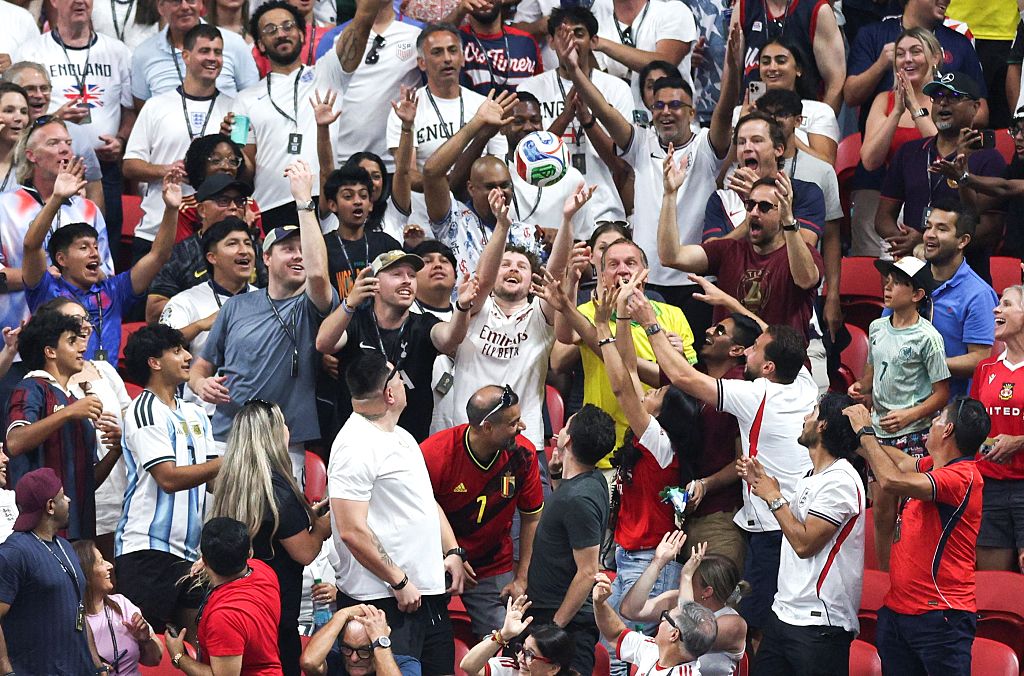 World Cup fans cheer as one tries to catch a ball