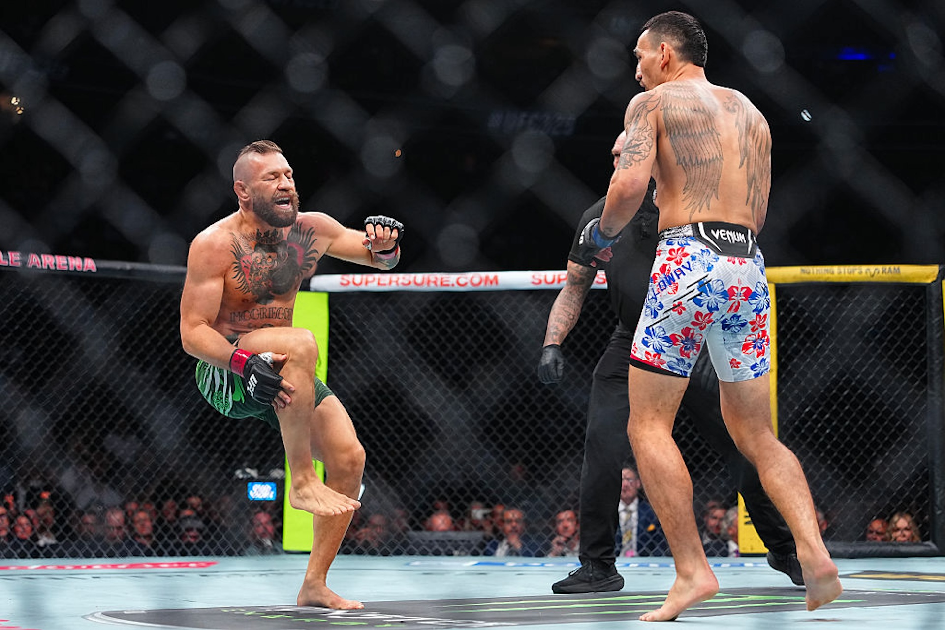 Conor McGregor grabs at his knee during his fight against max holloway