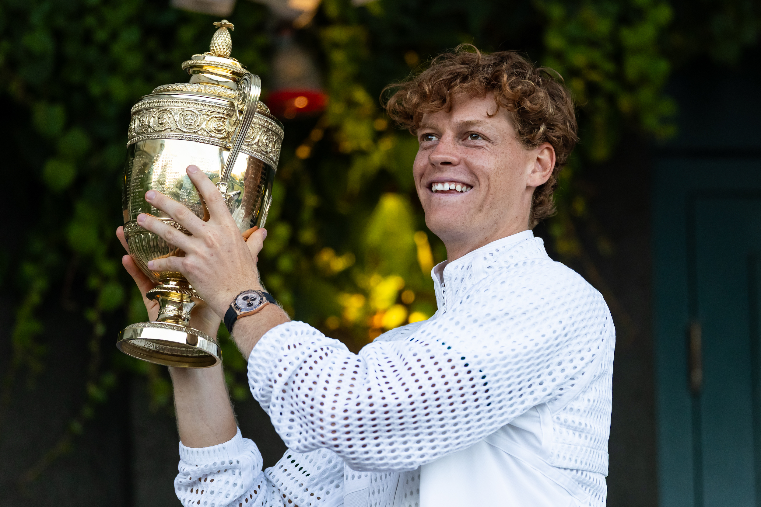 LONDON, ENGLAND - JULY 12: Jannik Sinner of Italy with his Gentlemen's Singles Trophy over the Royal Box balcony after his victory in the Gentlemen's Singles final match against Alexander Zverev of Germany on day fourteen of The Championships Wimbledon 2026 at All England Lawn Tennis and Croquet Club on July 12, 2026 in London, England. (Photo by Frey/TPN/Getty Images)