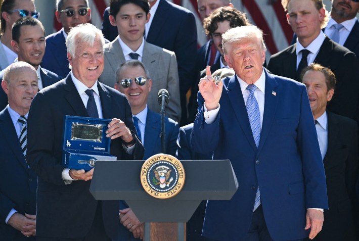 US President Donald Trump displays a ring presented to him by Los Angeles Dodgers owner Mark Walter (L) during a ceremony to honor the 2025 World Series champions in the Rose Garden at the White House in Washington, DC, on July 23, 2026.