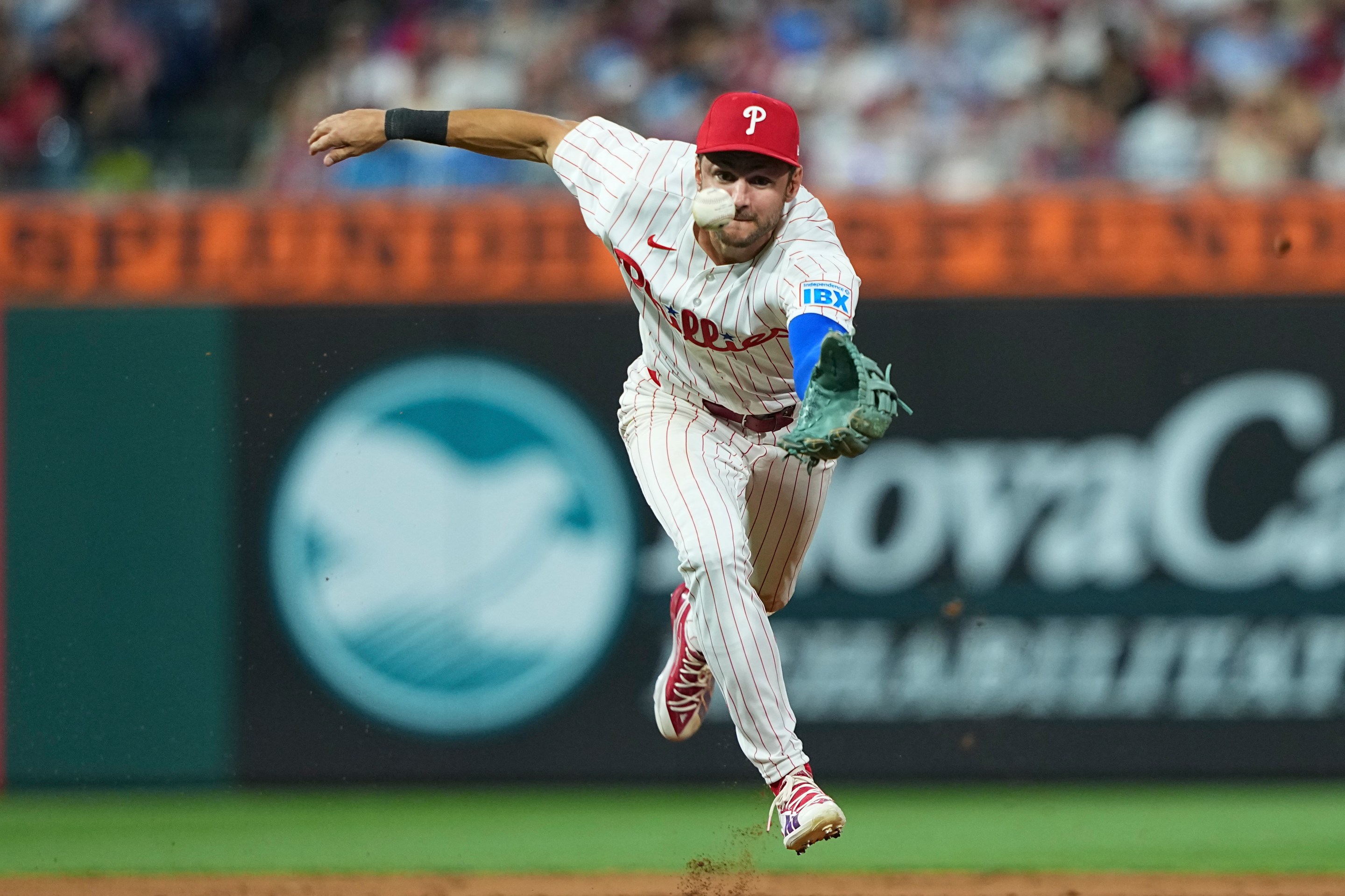 Trea Turner #7 of the Philadelphia Phillies cannot field the ball on an infield RBI single
