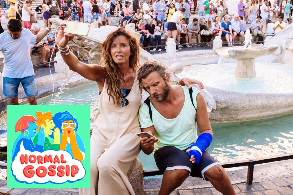 A young couple sitting at the Fontana della Barcaccia in Italy, the woman is attempting to take a selfie and the man is looking down at his phone