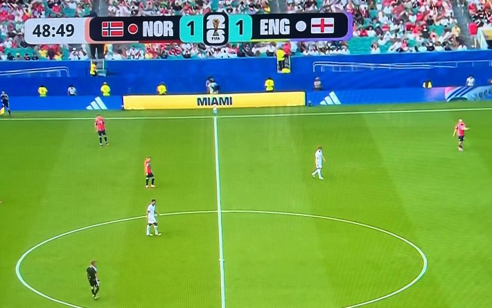 A photo showing the screen bug for Telemundo. It has a red dot for Noway and a white dot for England