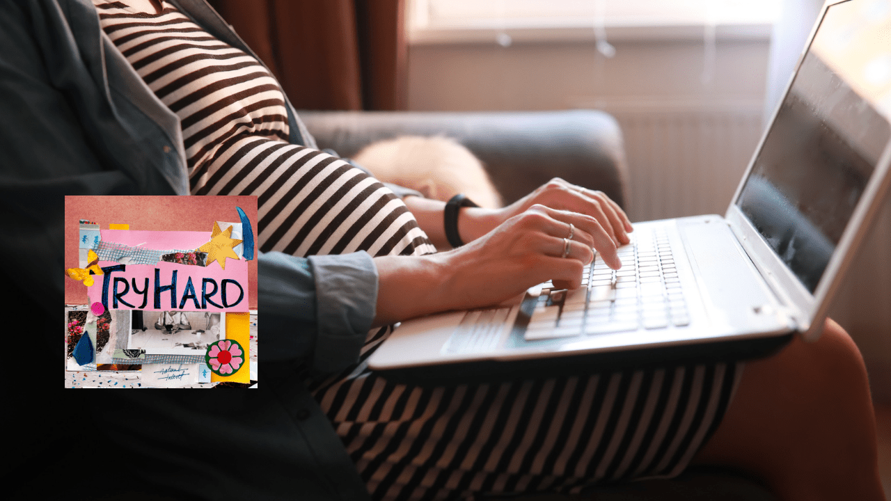 A pregnant woman sitting on the couch typing on her laptop