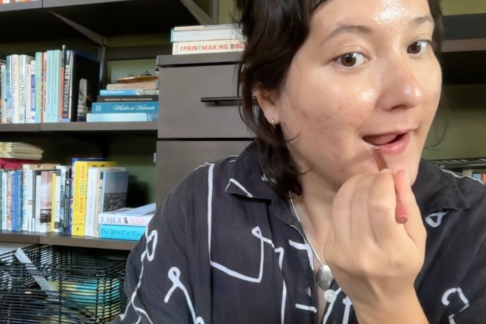 Alex applies pinky-mauve lip liner