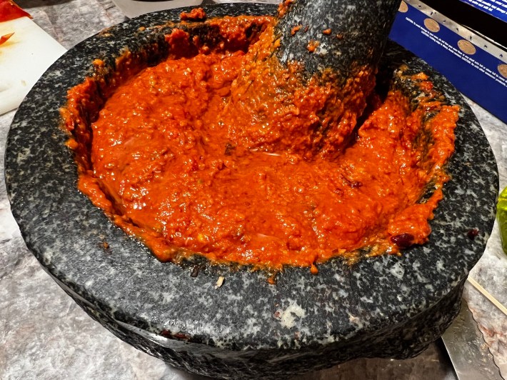 A mortar full of bright red Romesco.