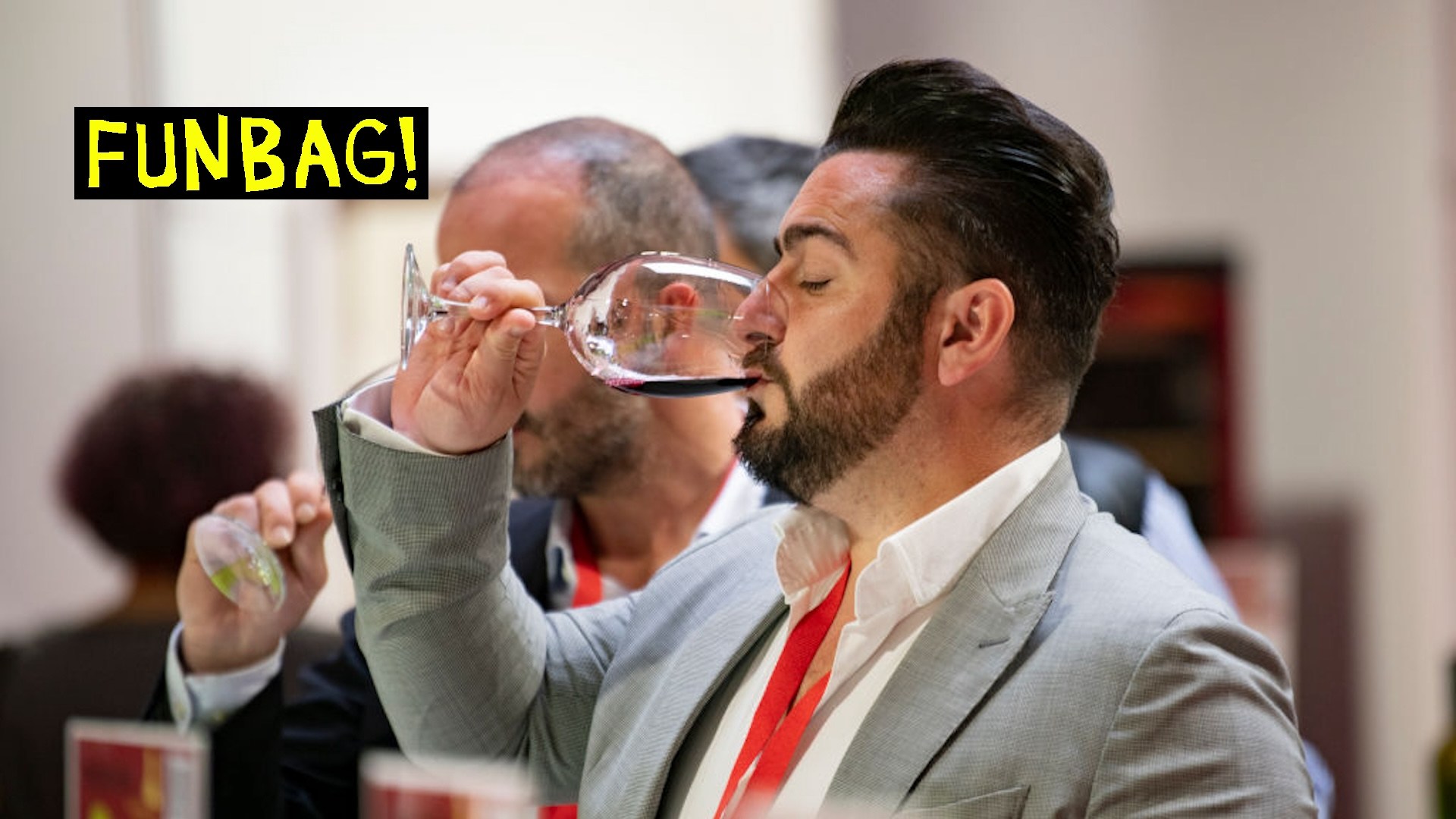 A man takes a small sip of wine