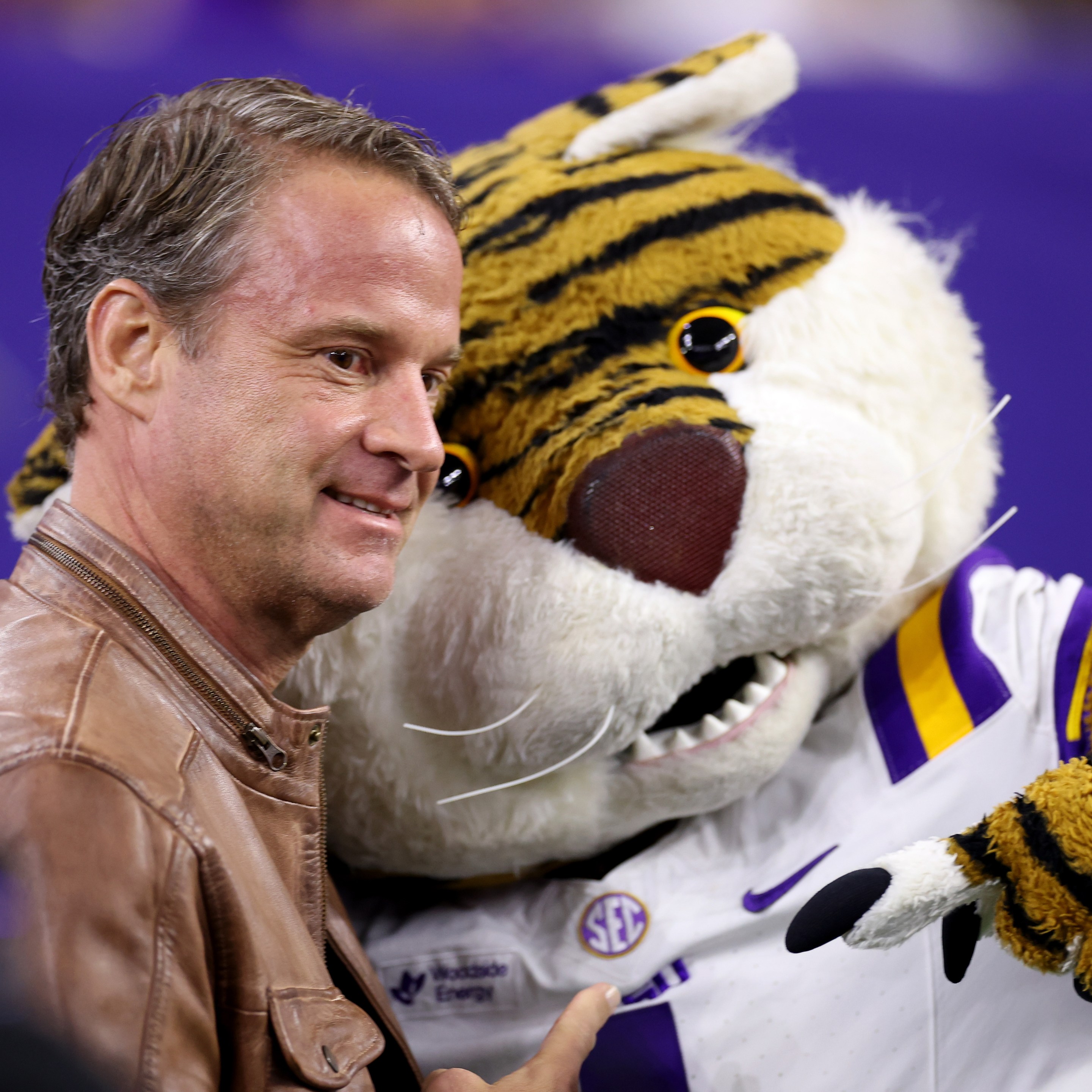HOUSTON, TEXAS - DECEMBER 27: Head coach Lane Kiffin of the Louisiana State Tigers poses with the mascot before the game against the Houston Cougars during the Kinder's Texas Bowl at NRG Stadium on December 27, 2025 in Houston, Texas.