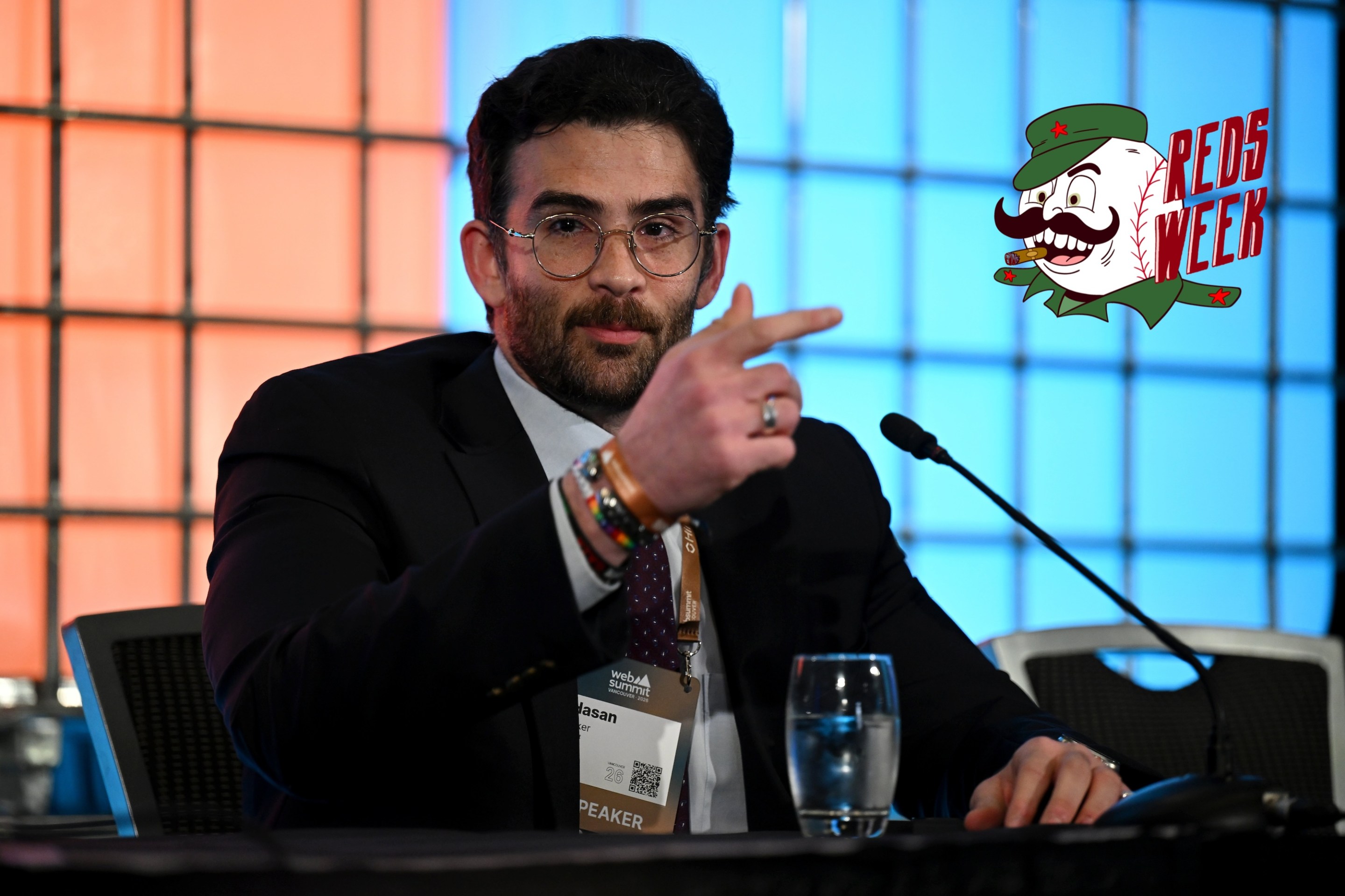 Hasan Piker, Streamer &amp; Creator, Night, at a press conference during day two of Web Summit Vancouver 2026 at Vancouver Convention Centre. The Reds Week logo is at right.