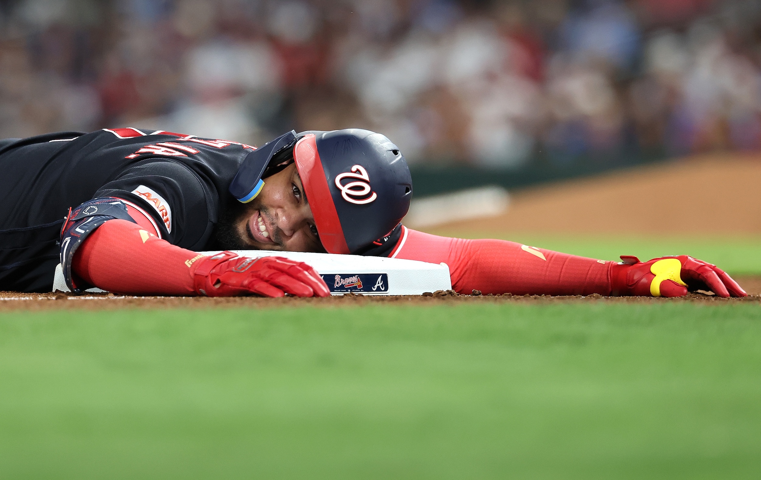Luis Garcia Jr. smiles and relaxes his head on third base after a triple.