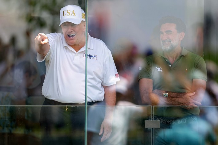 Donald Trump and Yasir Al-Rumayyan watch the golf at Bedminster.
