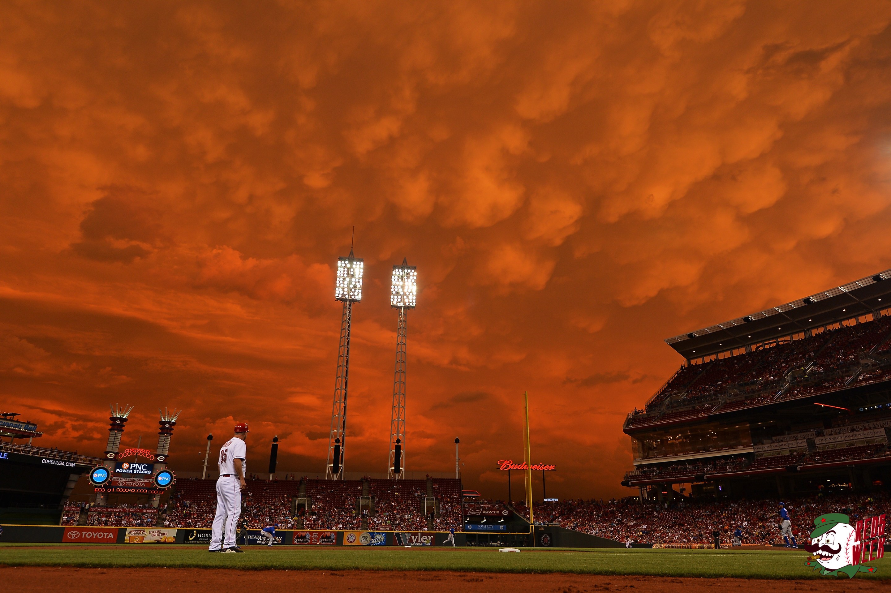Storm clouds blanket the sky over Great American Ball Park as Starlin Castro #13 of the Chicago Cubs fields a ground ball in the fifth inning against the Cincinnati Reds as on July 7, 2014 in Cincinnati, Ohio. Cincinnati defeated Chicago 9-3.