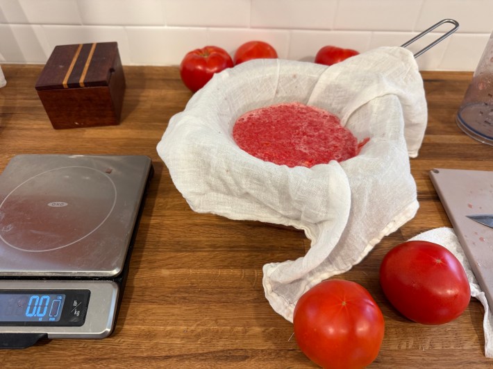 Tomato puree being strained through cheesecloth.
