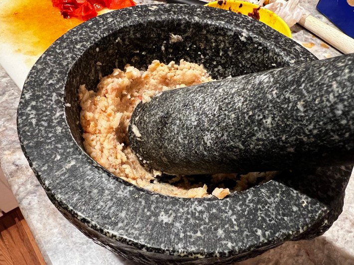 Smashed garlic and bread in a heavy mortar.