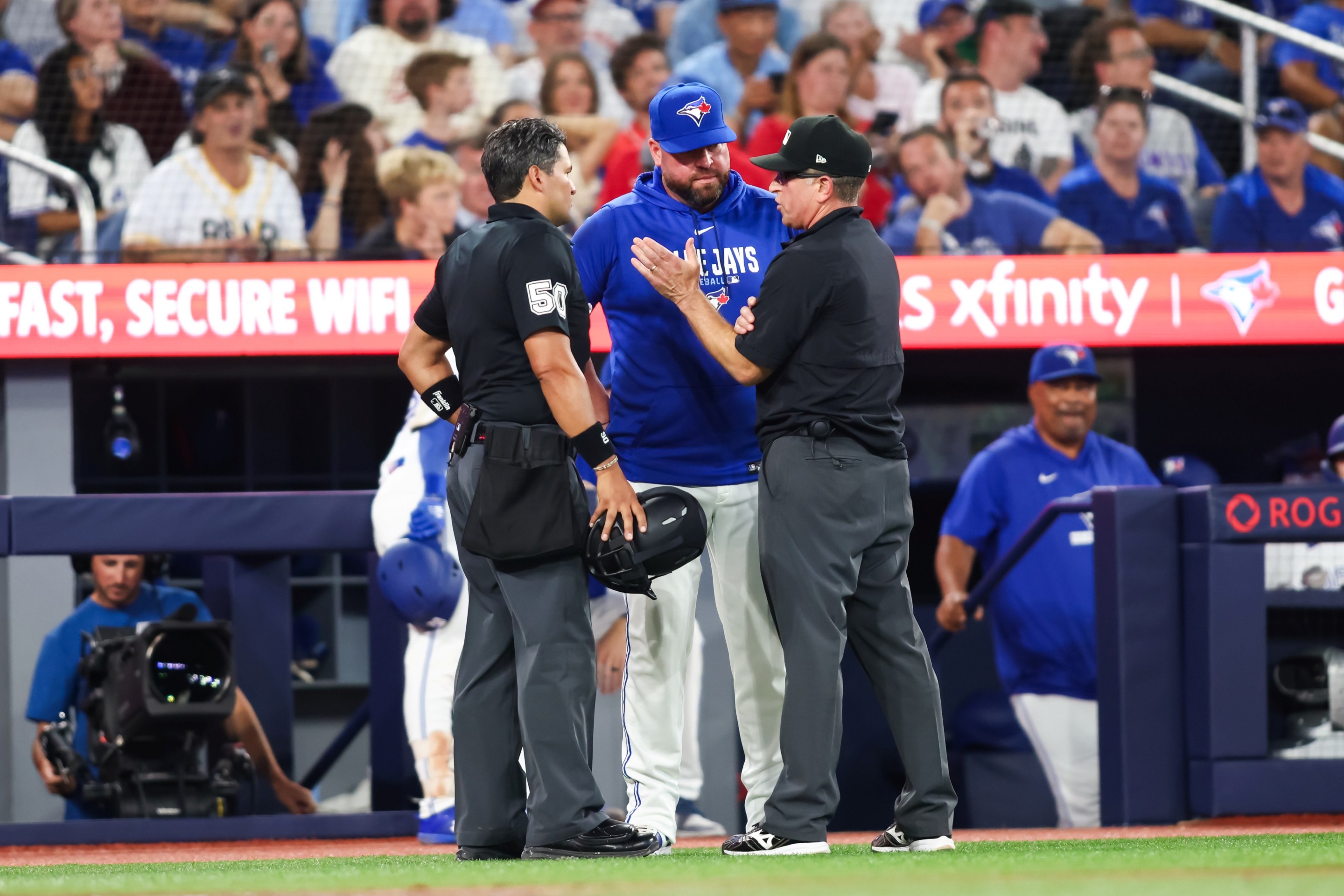 Umpires explain a rule review to manager John Schneider of the Toronto Blue Jays during the seventh inning of their MLB game against the Boston Red Sox.