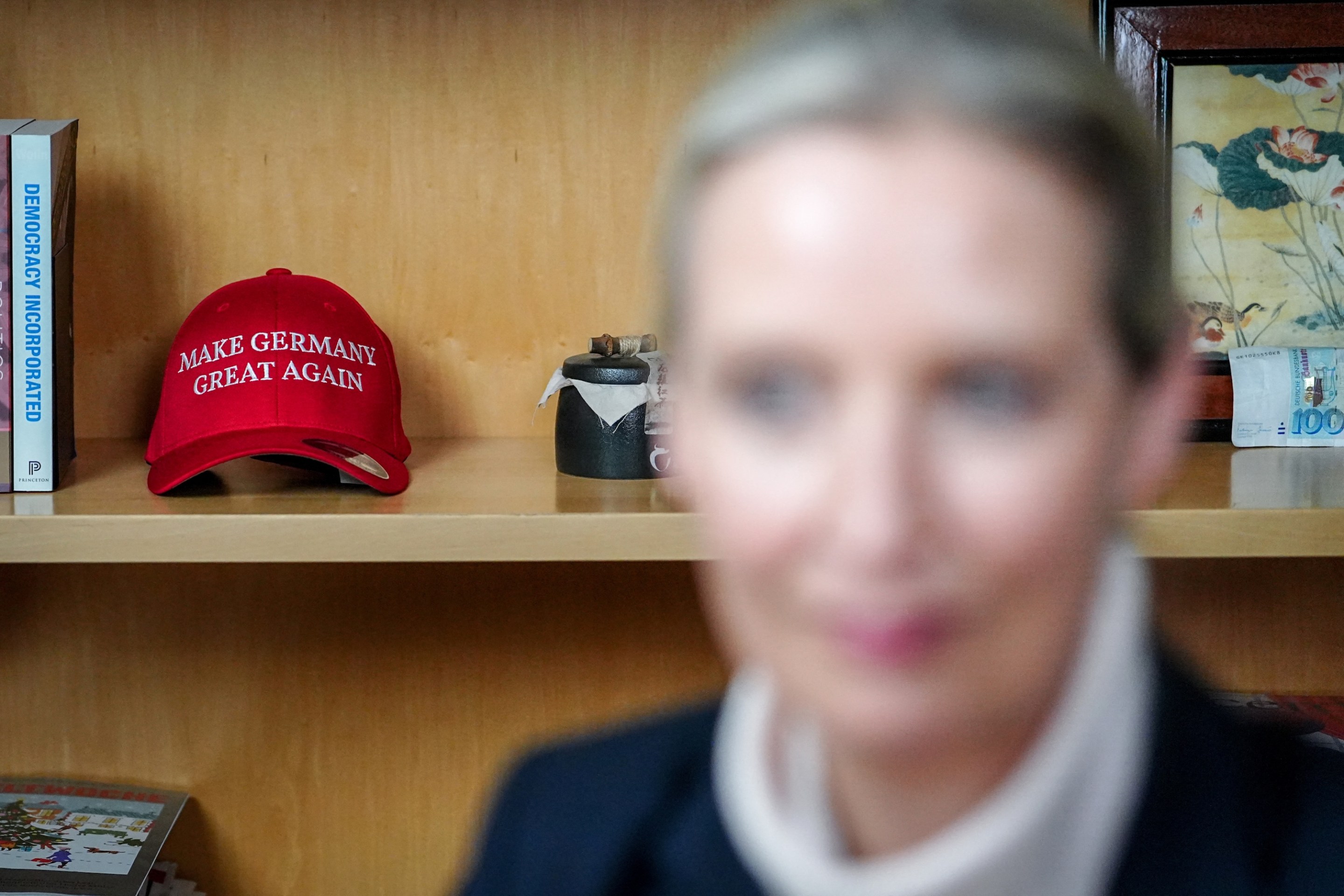 A basecap with the lettering 'Make Germany Great Again' is seen in a shelf behind co-leader of the far-right Alternative for Germany (AfD) party and the party's candidate for chancellor Alice Weidel prior to a live discussion with US tech billionaire and businessman Elon Musk on social network X, formerly known as Twitter, in her office at the Jakob Kaiser Building in Berlin on January 9, 2025. Musk is set to host a discussion on X with AfD's leader Weidel on Thursday. (Photo by Kay Nietfeld / POOL / AFP)