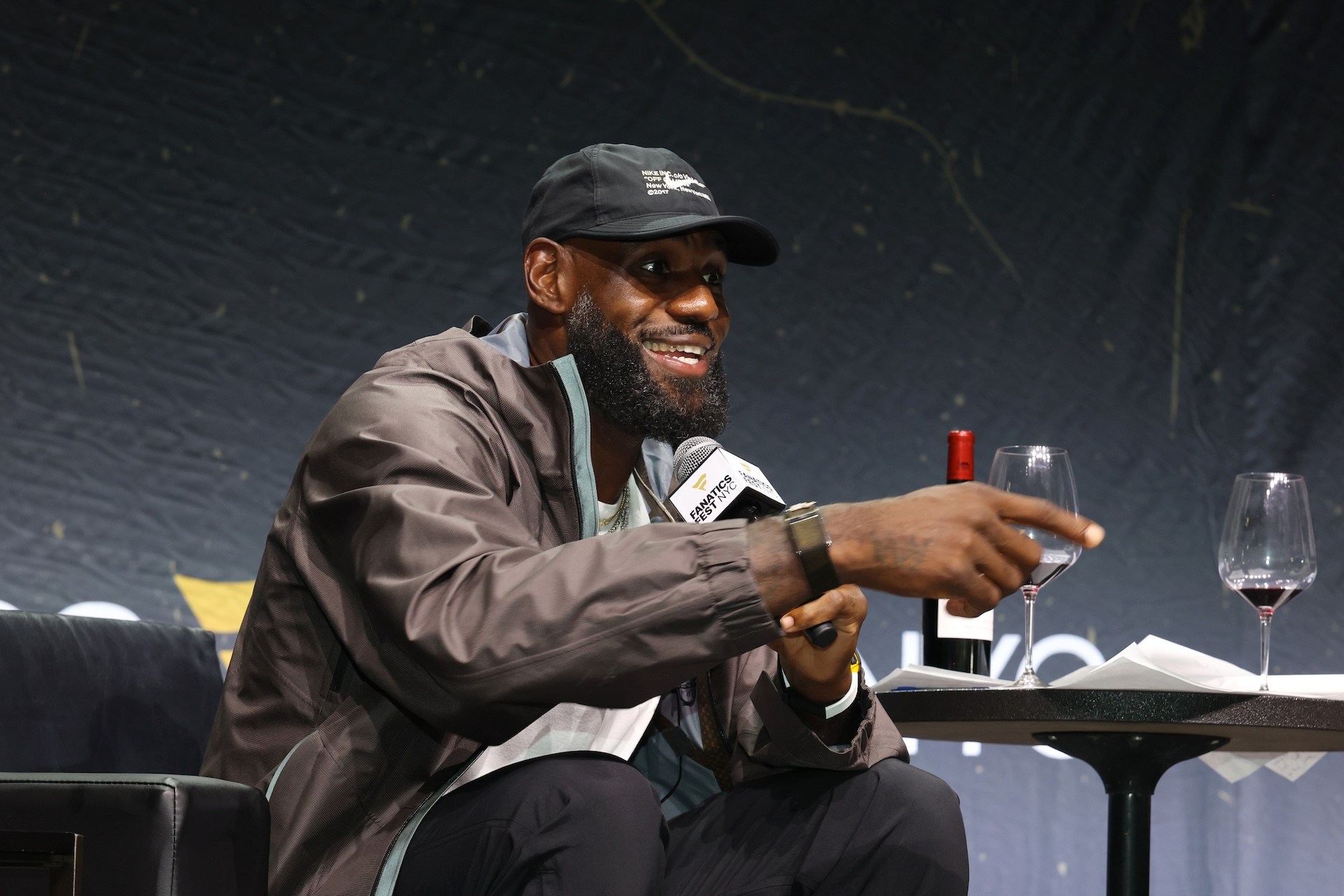 LeBron James smiles and gestures from the stage of some dumb event.