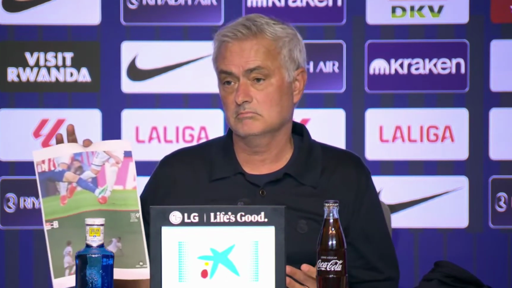 Jose Mourinho of Real Madrid holds up a printout with two fouls he believed should have been red cards for Atletico Madrid during the derby.