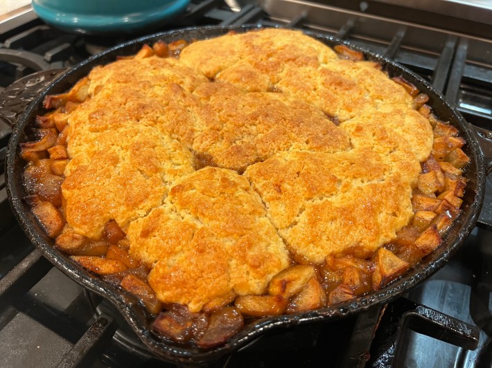 A baked apple cobbler in a cast iron skillet.