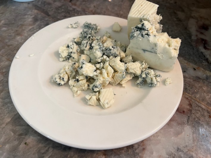 Blue cheese crumbled on a plate.