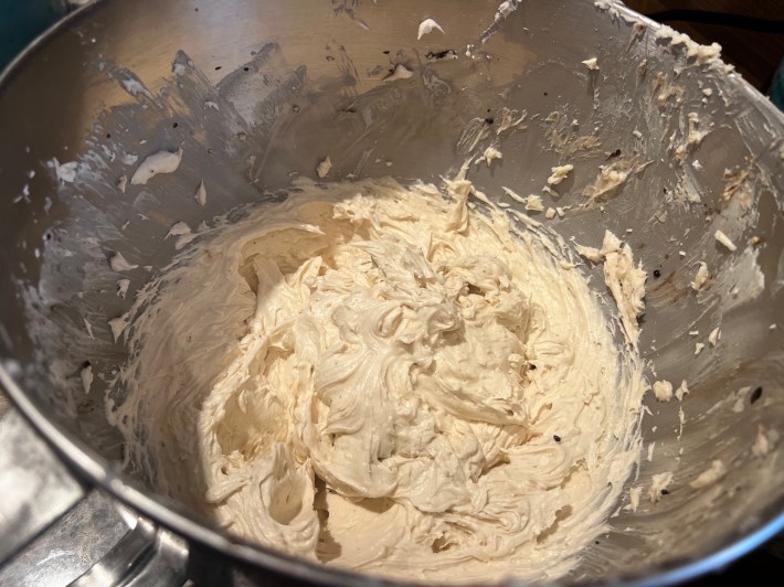 Finished buttercream icing sits in a metal bowl.