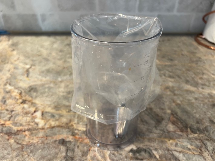 A piping bag pulled over a narrow plastic pitcher.