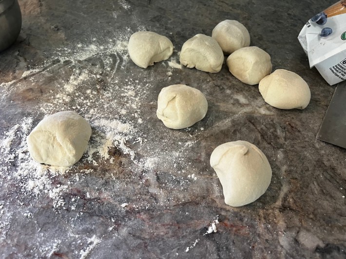 Eight roughly equal balls of raw dough.