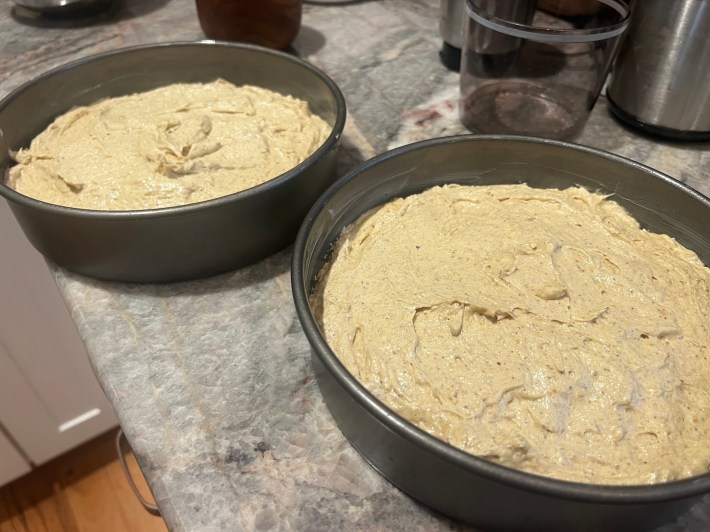 Two sponge tins half-full of cake batter.