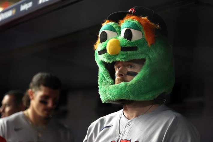 NEW YORK, NEW YORK - OCTOBER 01: Trevor Story #10 of the Boston Red Sox (R) wears a mask of mascot Wally the Green Monster after hitting a home run during the sixth inning to tie the game 3-3 against the New York Yankees in game two of the American League Wild Card Series at Yankee Stadium on October 01, 2025 in the Bronx borough of New York City. (Photo by Al Bello/Getty Images)