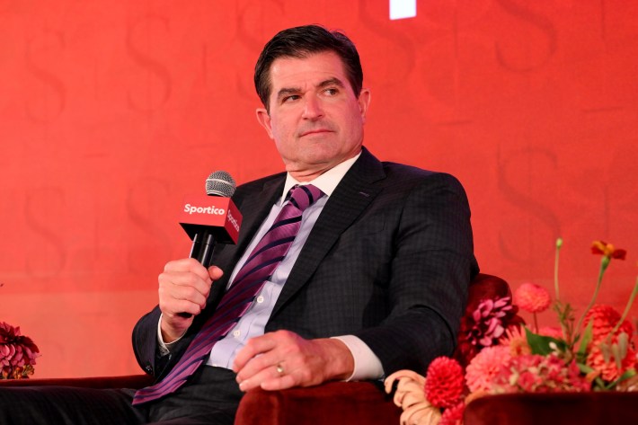 Scott O'Neil holds a microphone at a conference.