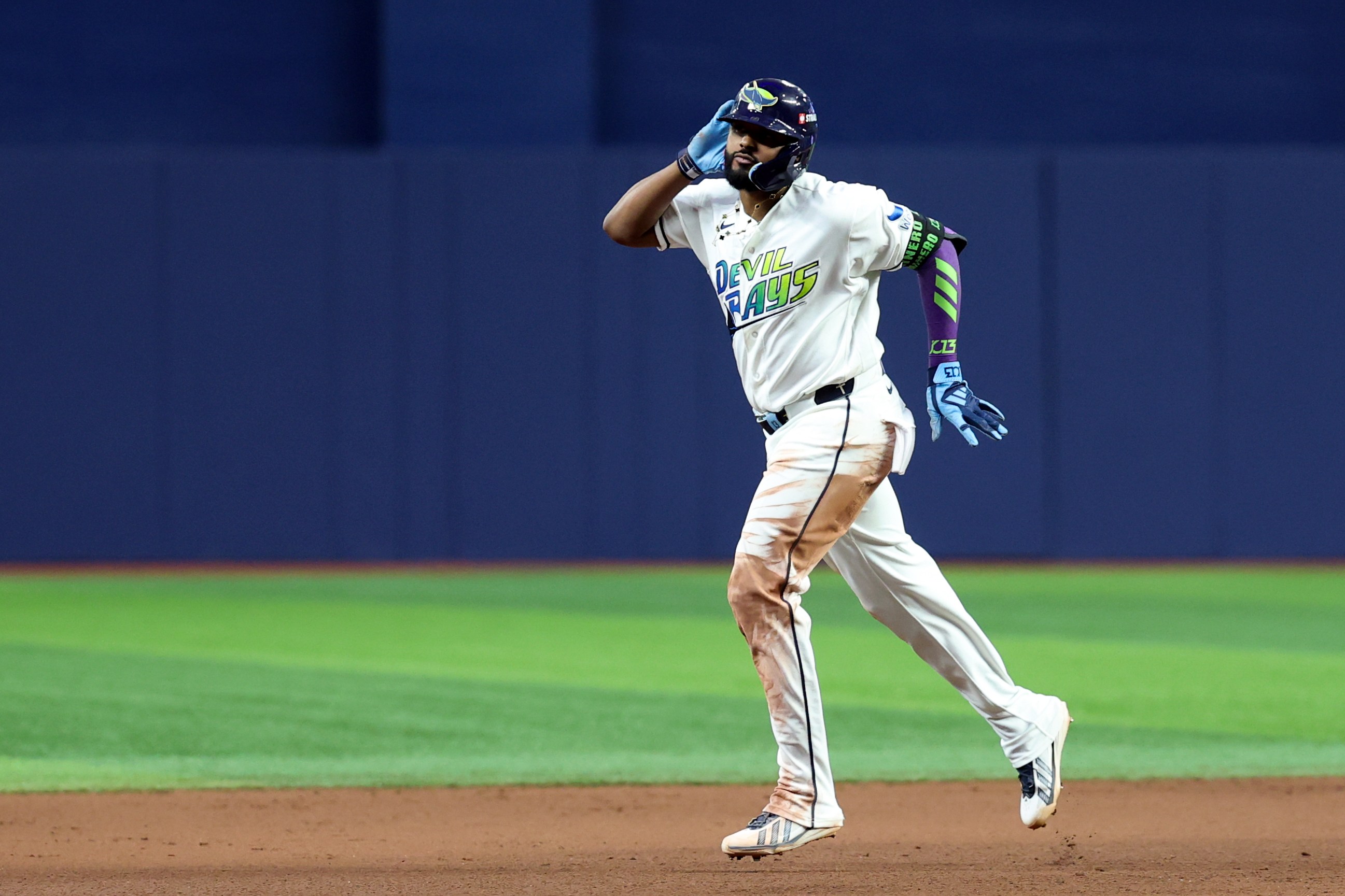 Junior Caminero #13 of the Tampa Bay Rays rounds the bases after hitting a two run home run in the seventh inning during Game Six of the American League Championship Series. He's got his hand up to his ear.