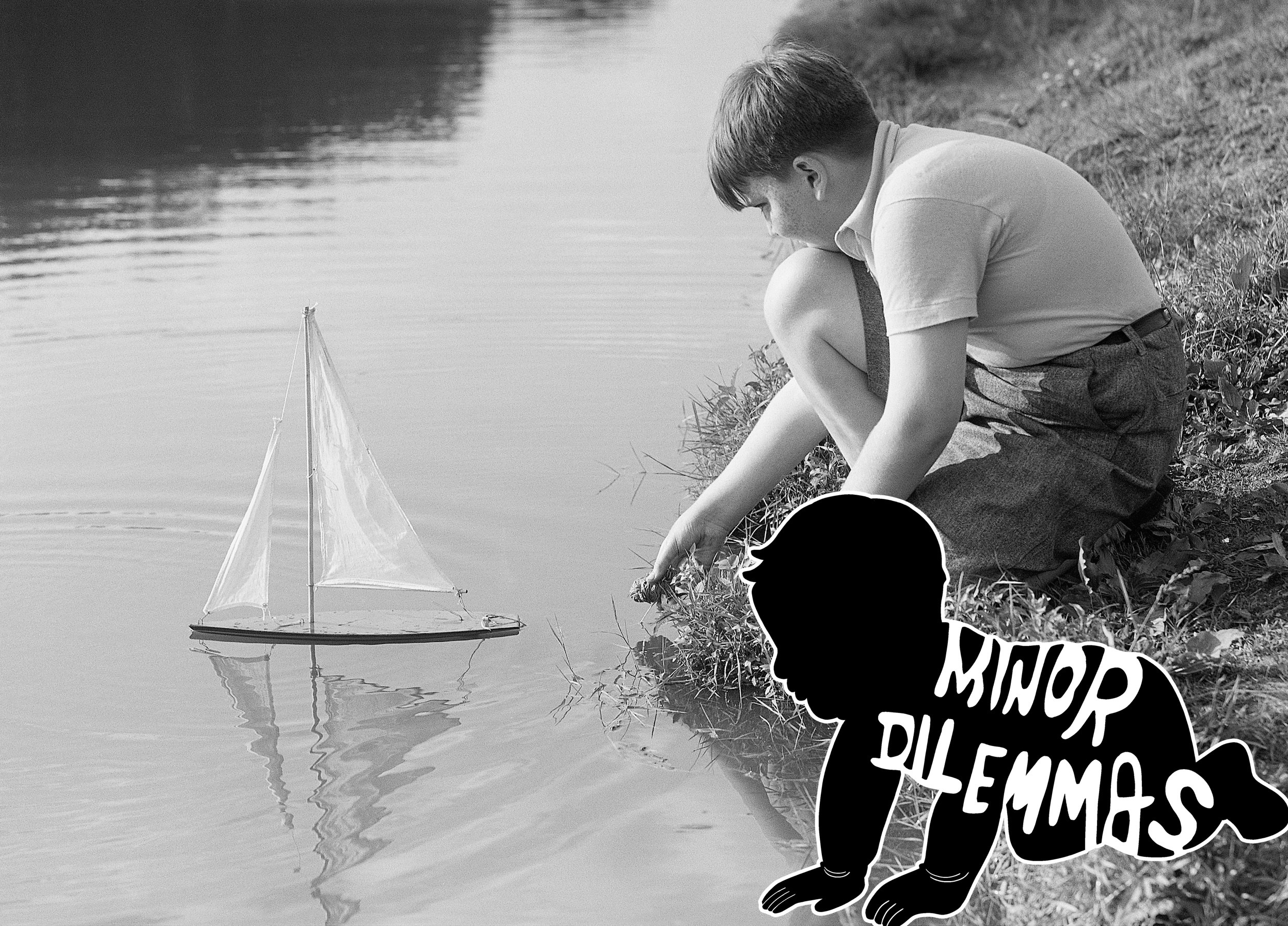 A boy pushes a toy sailboat out into a pond.