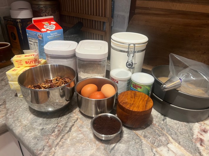 Baking ingredients arranged on a countertop, plus baking tins and a piping bag.
